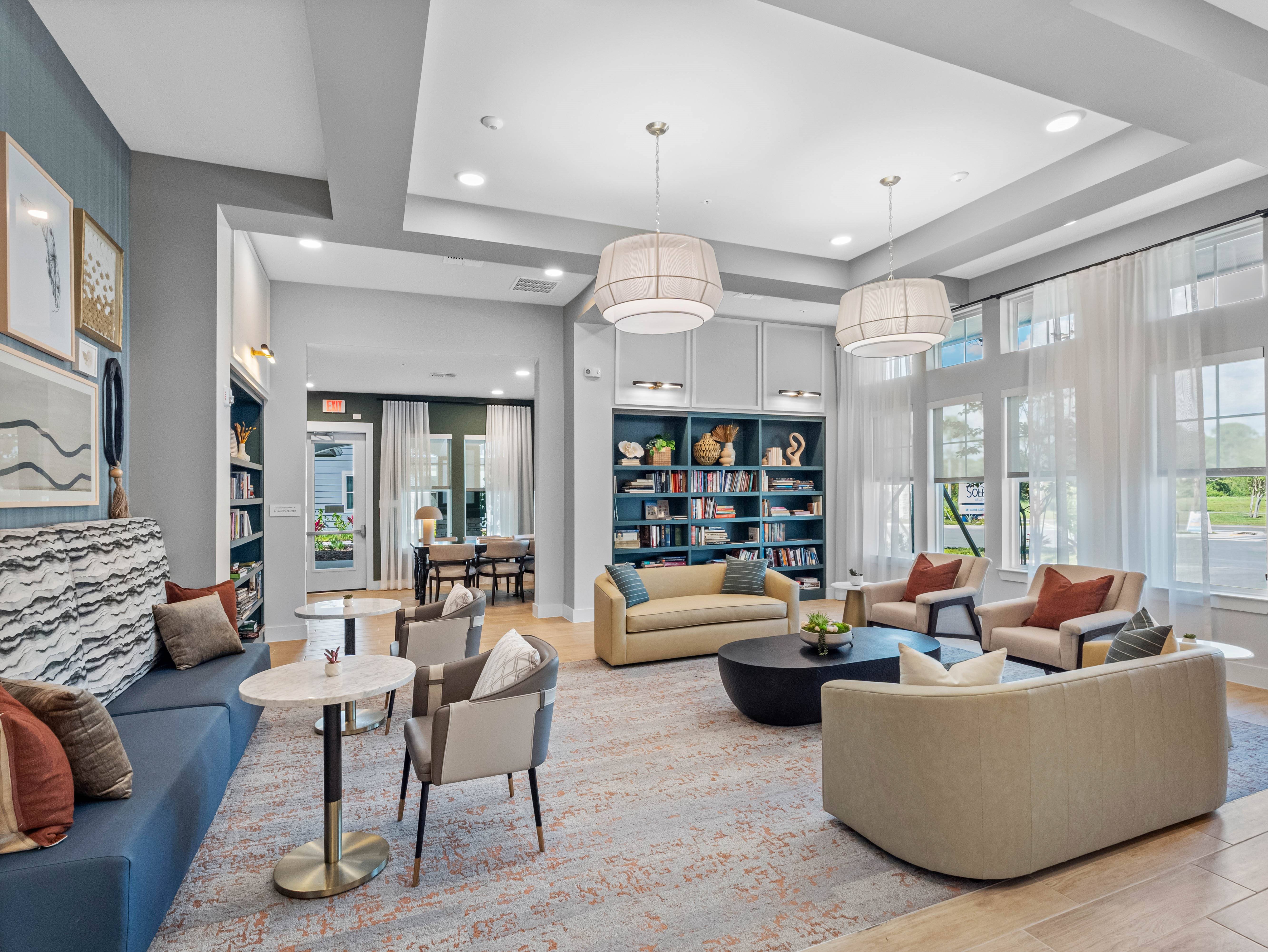 A living room with a blue sofa, a white coffee table, and a bookshelf filled with books.